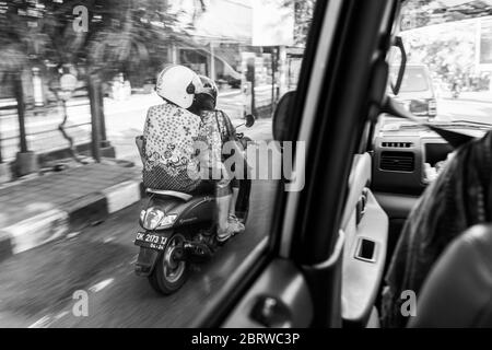 BALI, INDONESIA - 30 novembre 2019: Persone balinesi con bagagli enormi su scooter. Traffico su Bali. Indonesia Foto Stock