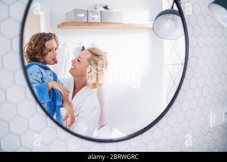 Un riflesso di madre e piccola figlia nello specchio del bagno. Foto Stock