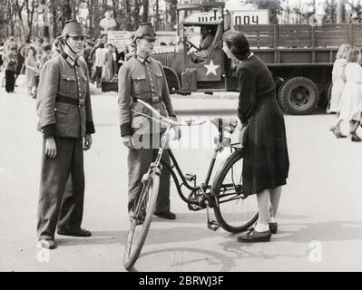 Fotografia della seconda guerra mondiale d'epoca - la polizia tedesca ha interrogato una donna nei giardini del Reichstag di Berlino in un'azione contro i mercanti neri. Agosto 1945 Foto Stock