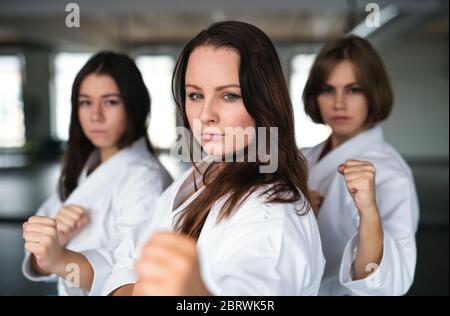 Gruppo di giovani donne che praticano il karate all'interno della palestra. Foto Stock