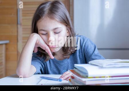 Il bambino si addormentò dalla noia mentre faceva i compiti Foto Stock