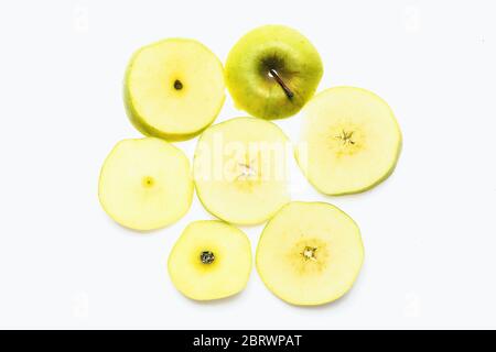 Mela tagliata in sette pezzi: Fette separate di mela verde poste in un cerchio che fa fiori di frutta isolati su sfondo bianco, vista dall'alto. Concetto di nutrizione sana Foto Stock