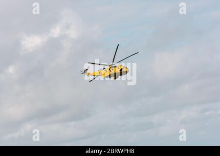 RAF Westland WS-61 Sea King caccia e salvataggio elicottero sulla pattuglia per controllare tutto è bene con i surfisti e nuotatori sulla spiaggia a Croyde Bay, Devon. Foto Stock