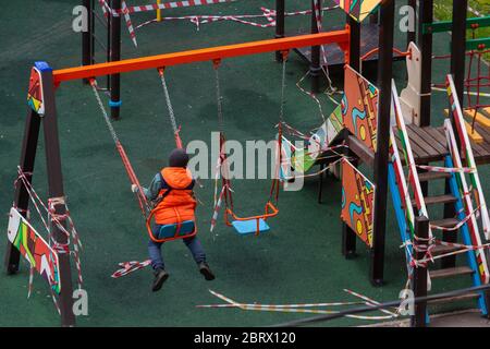 Mosca, Russia. 21 maggio 2020 Boy gioca su un parco giochi in un cortile di un edificio residenziale durante l'epidemia di coronavirus COVID-19 a Mosca, Russia Foto Stock