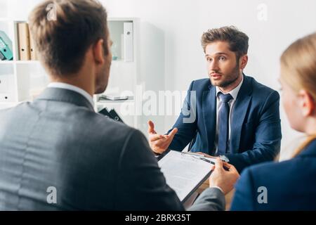 Concentrazione selettiva del dipendente che guarda il reclutatore durante il colloquio di lavoro Foto Stock