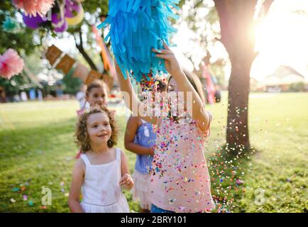 Bambini piccoli all'aperto in giardino in estate, giocare. Foto Stock