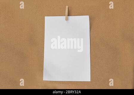 Graffetta bianca e graffetta di legno su sfondo di carta marrone. Foto Stock