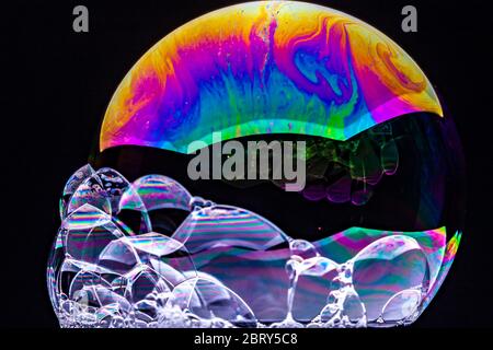 Primo piano Caleidoscopio di bollicine colorate e vorticose fotografate in studio con sfondo nero Foto Stock