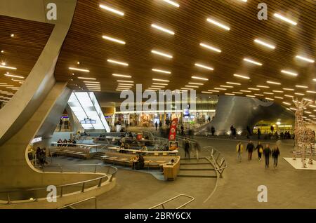 Arnhem, Paesi Bassi, 27 dicembre 2019: La sala centrale della nuova stazione ferroviaria scultorea con fast food e soffitto in legno Foto Stock