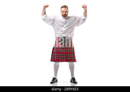 Forte uomo scozzese rosso in kilt rosso che mostra pugni su sfondo bianco Foto Stock