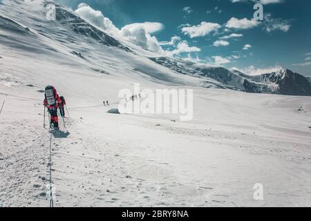 Escursione di arrampicata sul ghiacciaio. Paesaggio panoramico di montagne innevate. Turismo estremo. Lavoro di squadra. Foto Stock