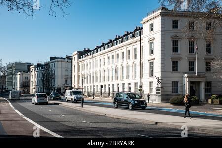 Una scena di strada londinese nel quartiere di Pimlico con traffico che passa attraverso case cittadine georgiane lungo Millbank. Foto Stock