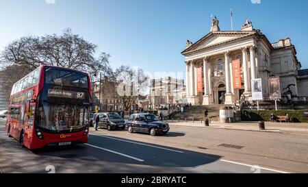 Il museo e la galleria Tate Britain a Millbank, Westminster, con un autobus a due piani di Londra che passa in primo piano. Foto Stock