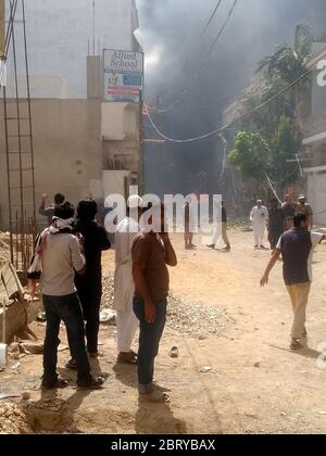 Karachi. 22 maggio 2020. La foto scattata con un telefono cellulare mostra i residenti locali che si riuniscono presso il sito di incidente aereo nella città portuale pakistana meridionale di Karachi il 22 maggio 2020. Un aereo passeggeri della Pakistan International Airlines (PIA) che trasportava circa 100 persone si è schiantato in una zona residenziale il venerdì pomeriggio a Karachi, secondo i media locali e un funzionario. Credit: Sr/Xinhua/Alamy Live News Foto Stock