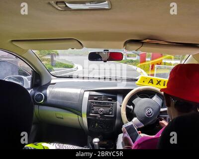 Taxi driver a Cape Town, Sud Africa. In auto, taxi, mentre la guida del sedile posteriore. Foto Stock