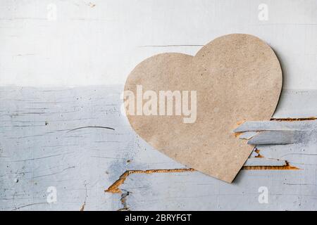 Cuore di carta su una parete rustica, porta come simbolo di amore Foto Stock