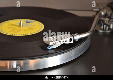 Un braccio luminoso segue le scanalature del disco e il suono riempie la stanza Foto Stock