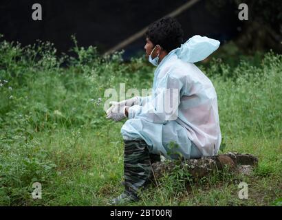 Guwahati, Assam, India. 22 maggio 2020. Un lavoratore comunale si riposa dopo il lavoro in un centro di quarantena, durante il blocco COVID-19 in corso, a Guwahati. Credit: David Talukdar/ZUMA Wire/Alamy Live News Foto Stock