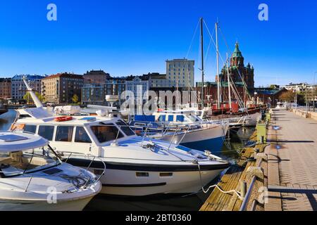 Passeggiata di Pohjoisranta al mattino soleggiato con barche da diporto e Katajanokka con la Cattedrale di Uspenski sullo sfondo. Helsinki, Finlandia. Maggio 2020 Foto Stock