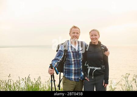Due escursionisti, uomo e donna, abbracciano un sentiero costiero Foto Stock