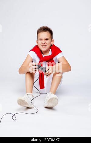 teenager gioca emotivamente un computer o console di gioco utilizzando il joystick. Foto Stock