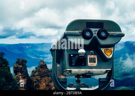 Binocoli a gettoni gestiti a Echo Point Lookout ha indicato verso le tre sorelle formazione rocciosa e Jamison Valley nelle Blue Mountains, Australia Foto Stock