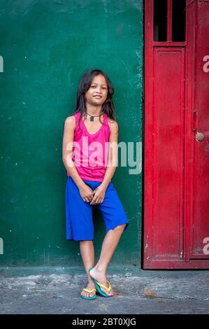 Una giovane ragazza filippina si pone e sorride per la mia macchina fotografica nella vecchia città murata di Intramuros, Manila, Filippine. Foto Stock