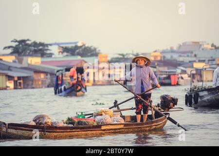 Delta Mekong - Vietnam - 24 gennaio 2019 : il venditore vietnamita fila la sua barca sul mercato galleggiante Nga Nam nel Delta del Mekong Vietnam. Foto Stock