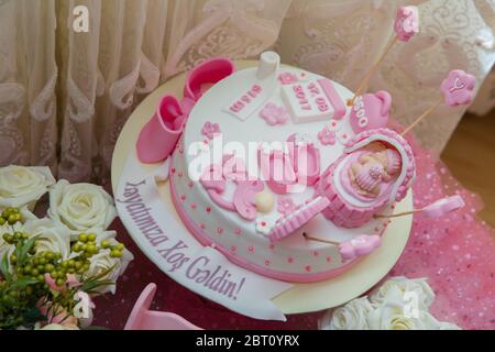 Torta di tema rosa e bianco per il bambino. Torta di compleanno della ragazza del neonato . Scarpe per bambini . Il peso, la data di nascita, l'ora e la durata del bambino sono scritti Foto Stock