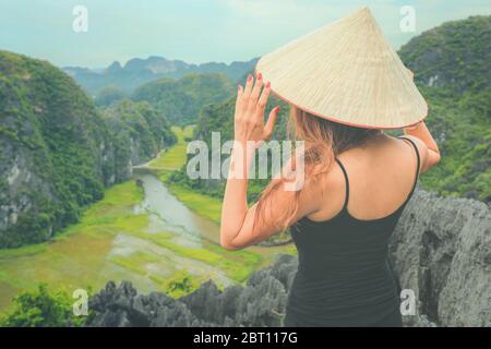 Viaggiatrice in Vietnam. Giovane donna asiatica in piedi sulla cima Mua Cave. Provincia di Ninh Binh, Vietnam. Foto Stock