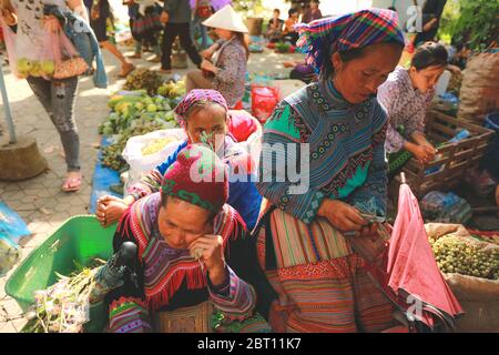 Sapa, Vietnam - 7 luglio 2019 : donne Hmong che vendono vetrettable nel mercato di Bac ha, Vietnam del Nord. Bac ha è mercato delle tribù delle colline dove la gente viene a trad Foto Stock