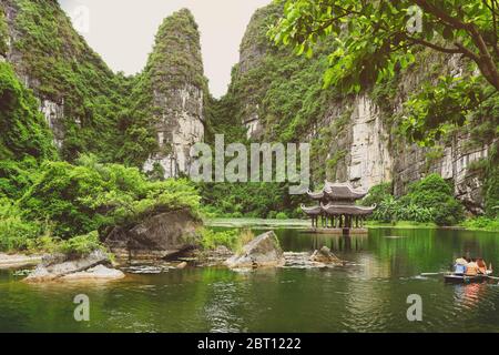 Turisti in barca a remi al complesso Trang An Landscape nella provincia di Ninh Binh in Vietnam Foto Stock