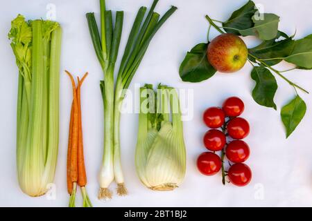 Piatto con diversi tipi di verdure fresche locali e frutta come, sedano, cipollina, pomodoro, mela, zucchine, cicoria e finocchio Foto Stock