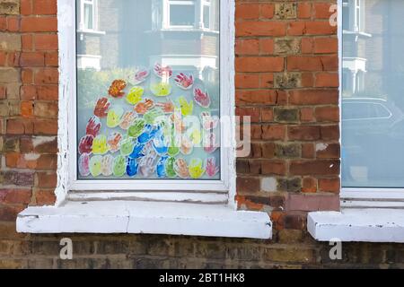 Londra, Regno Unito - 04 maggio 2020: Arcobaleno fatto di stampe colorate a mano esposte sulla finestra locale di casa a Lewisham, come segno di apprezzamento t Foto Stock