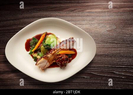 Direttamente sopra un'elegante piatto di cucina Nouvelle con maiale arrosto affettato su verdure Foto Stock