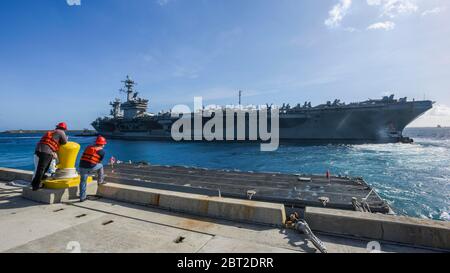 Apra Harbour, Stati Uniti. 09 marzo 2020. La portaerei della marina statunitense di classe Nimitz USS Theodore Roosevelt viene trainata fuori dal molo quando parte dalla base navale Guam 21 maggio 2020 ad Apra Harbour, Guam. L'equipaggio negativo del COVID è tornato dalla quarantena e sta tornando in mare per continuare il loro dispiegamento programmato nell'Indo-Pacifico. Credito: MC3 MacAdam Weissman/USA Notizie dal vivo sulla Marina/Alamy Foto Stock