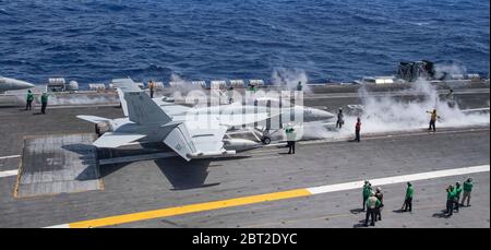 Filippine, Stati Uniti. 22 maggio 2020. I marinai della Marina statunitense a bordo della portaerei di classe Nimitz USS Theodore Roosevelt si preparano a lanciare un aereo da guerra elettronico e/A-18 Growler, assegnato ai Lupi grigi di VAQ 142 22 maggio 2020 nel Mare delle Filippine. L'equipaggio negativo COVID è tornato dalla quarantena e la nave ha continuato il loro dispiegamento programmato nell'Indo-Pacifico. Credito: MCS Kaylianna Genier/USA Notizie dal vivo sulla Marina/Alamy Foto Stock