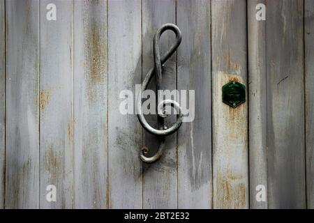 Maniglia per porta a forma di TREBLE Clef su una porta in legno Foto Stock