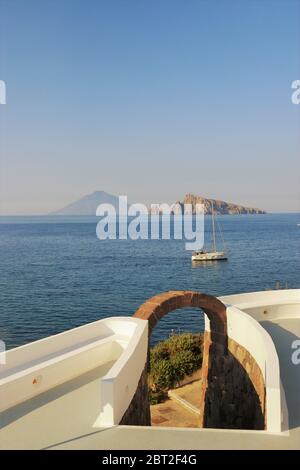 Navigando lungo le Isole Eolie in Sicilia, Italia, con vista sul vulcano Stromboli sullo sfondo. Foto Stock