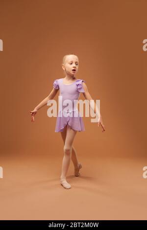 ragazza in un abito viola mostra elementi di balletto Foto Stock