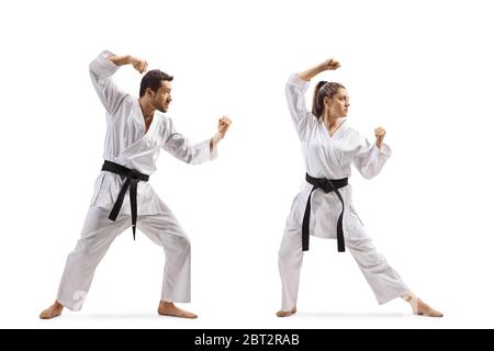 Foto a lunghezza intera di un giovane uomo e donna con cinture nere che praticano il karate isolato su sfondo bianco Foto Stock