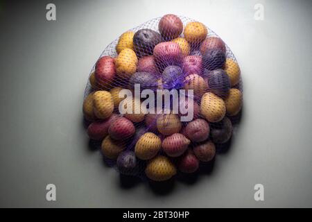 Patate creme tricolore in sacchetto a maglia Foto Stock