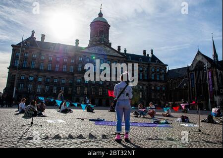 Un attivista del clima ha tenuto un discorso al centro della piazza.l'estinzione Rebellion Nederland ha organizzato un'azione di moda XR, per mostrare un'alternativa alla frenetica industria della moda. Circa venti attivisti si sono esibiti in piazza Dam, nel centro di Amsterdam, per cucire e riparare i vestiti usati, per sostenere le piccole etichette di moda sostenibili che stanno attraversando un momento difficile, e due volte pensando prima di acquistare nuovi vestiti. Durante l'azione, e secondo le regole di Coronavirus, gli attivisti hanno mantenuto la distanza sociale. Foto Stock