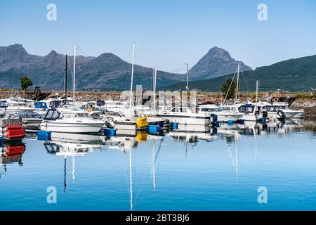 Nesna, Norvegia - 06 agosto 2019: Vista al porto turistico di Nesna: Un sacco di barche a motore, barche a vela, barche di pescatori in calmo oceano blu. Viaggio a Nesna, cal soleggiato Foto Stock