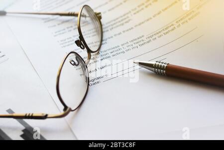 Accordo con penna e occhiali. Messa a fuoco selettiva. Concetto di carriera per ufficio aziendale Foto Stock