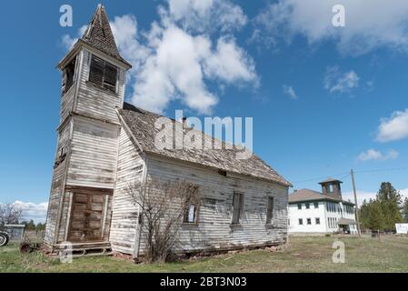 Vecchia chiesa pendente e scuola nella città fantasma di Flora, Oregon Foto Stock