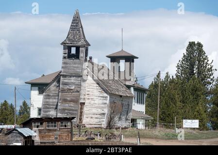 Vecchia chiesa pendente e scuola nella città fantasma di Flora, Oregon Foto Stock