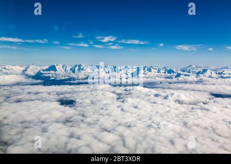 Vista aerea della catena montuosa delle Alpi sopra le nuvole viste dall'aereo sulla Svizzera Foto Stock