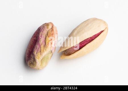 Due pistacchi freschi isolati su sfondo bianco Foto Stock