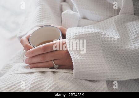 Donna in abito da spogliatoio che gusta una tazza di tè Foto Stock